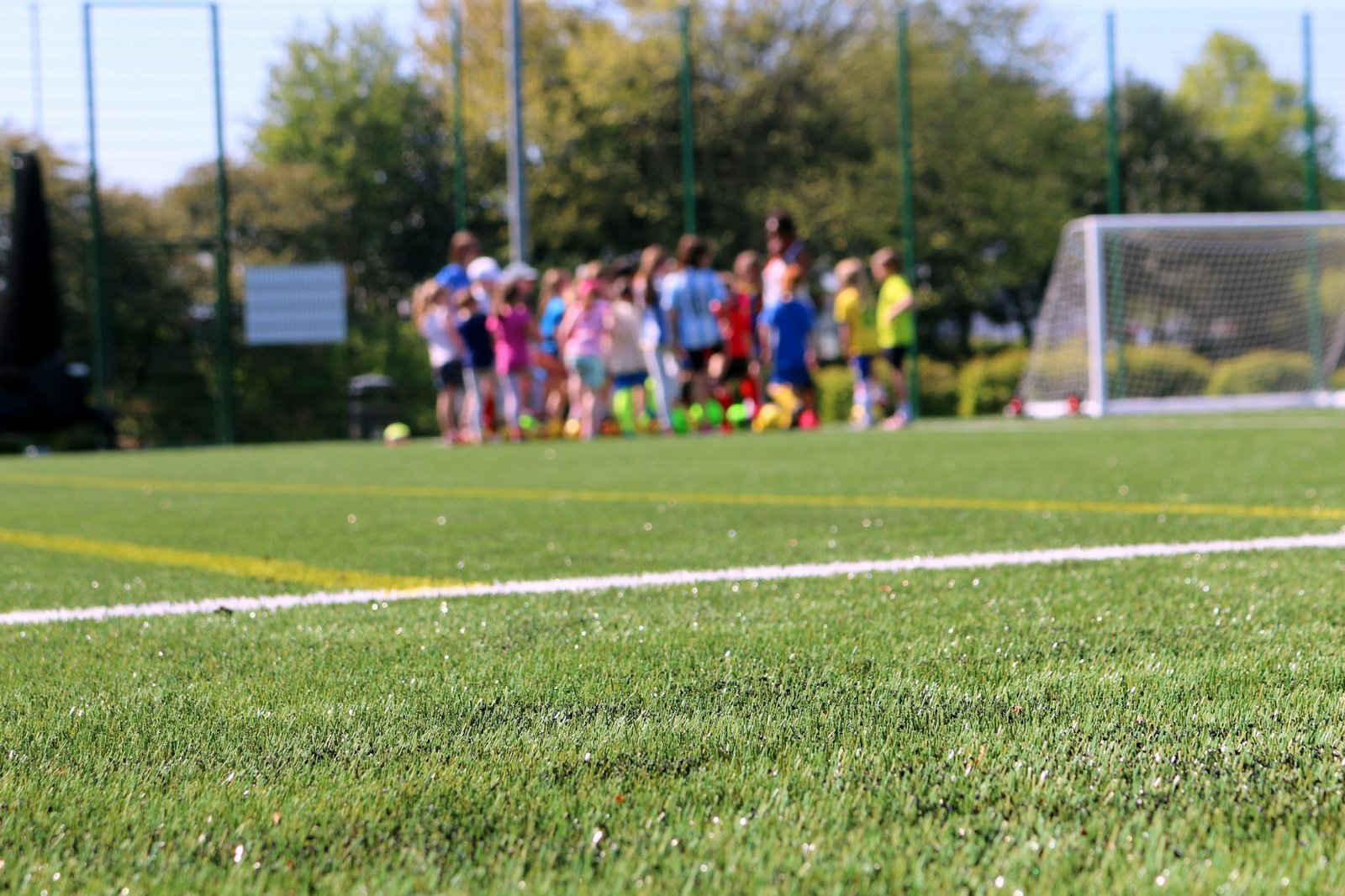 Children practising soccer on a green field